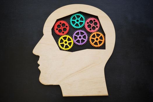 Wooden Head shape and colorful gears inside. Mental health concept.