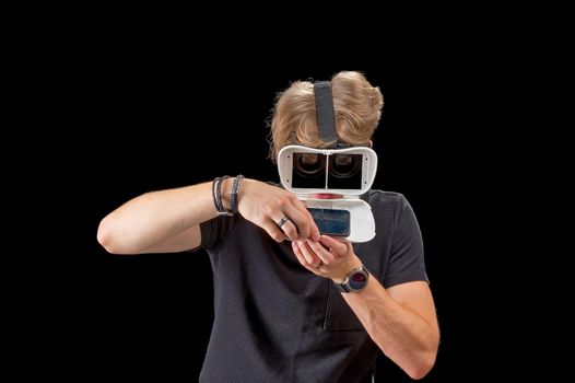 Portrait of a young man with 3D virtual reality glasses. Young man using white virtual reality headset, VR, future, goggles, technology concept on black background.