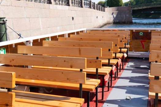 RUSSIA, PETERSBURG - AUG 20, 2022: an empty Petersburg bench wooden excursion background white garden seat, from rest design in modern and exterior plank, patio terrace. Natural ,