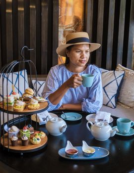 Asian women having a Luxury high tea with snacks and tea in a luxury hotel