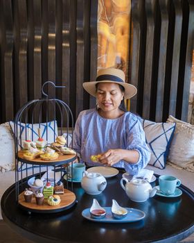 Asian women having a Luxury high tea with snacks and tea in a luxury hotel