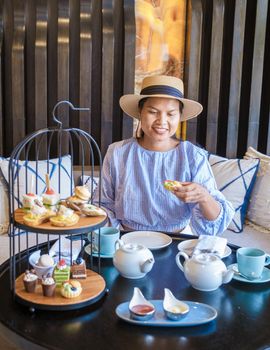 Asian women having a Luxury high tea with snacks and tea in a luxury hotel