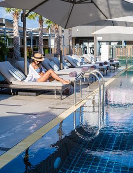 Rooftop swimming pool at a luxury hotel, luxury pool on a rooftop looking out over ocean. couple men and women on a rooftop swimming pool at a luxury hotel