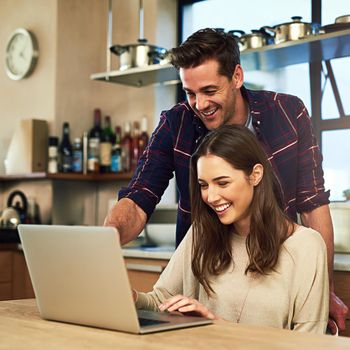 Doing some online browsing together. a young couple using a laptop together at home