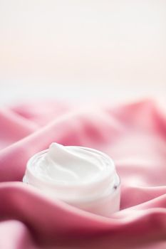 Beauty, anti-age cosmetics and skincare concept - Luxury face cream jar on a soft pink silk