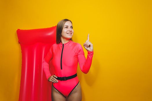 Young woman slim body pink one piece swimsuit on pink air mattress isolated on bright yellow color studio background summer hotel swimming pool sea vacation sun tanning concept. Place for text
