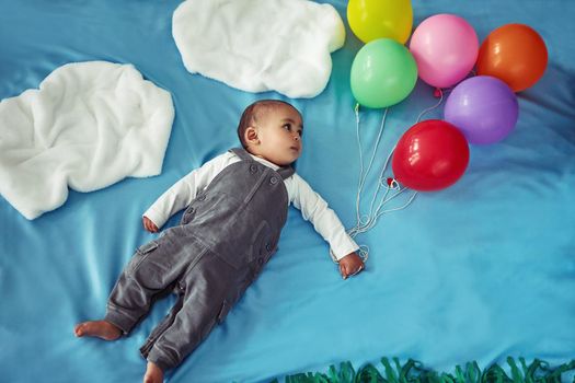 From here on, the skys the limit. Concept shot of an adorable baby boy flying through the sky holding a bunch of balloons