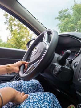 Beautiful business lady driving her car a cloudy day in summertime