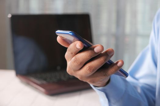 Close up of young man hand using smart phone