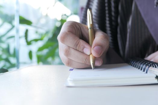 Close up of women hand writing on notepad