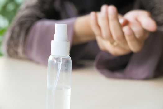 selective focus. sanitizer gel on table and women using sanitizer gel on background