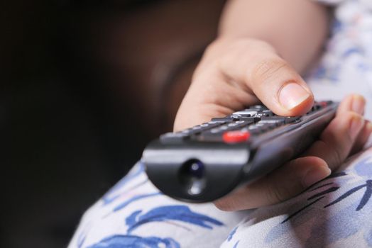 close up of women hand holding tv remote.