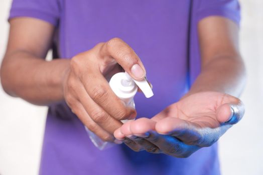 close up of young man hand using sanitizer gel for preventing virus.