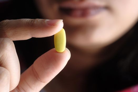 young women hand holding pills close up .