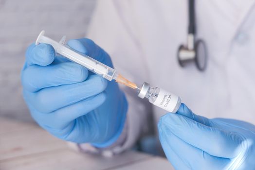 Doctor hands in medical gloves holds syringe and vaccine