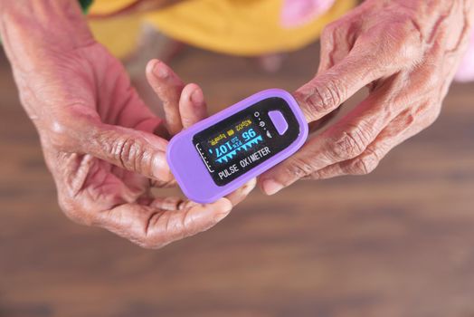 senior women hand using pulse oximeter.