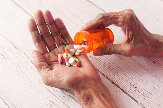senior women hand's taking medicine, close up .