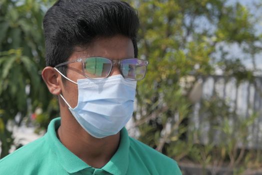 thoughtful young man with protective mask outdoor .