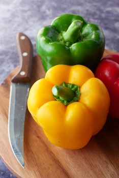 Yellow, green and red capsicum on wooden background .