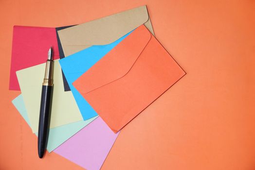 colorful envelope on orange background with copy space..