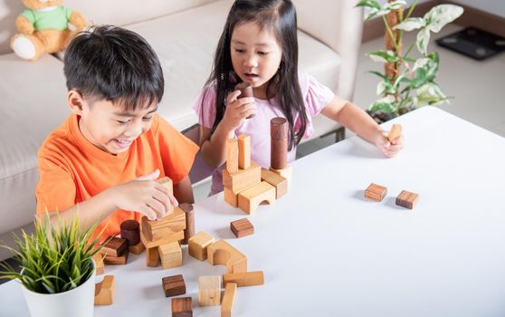 Children boy and girl playing with constructor wooden block building, Happy little kids play wood block stacking board game at home, activities learning creative, toys for preschool and kindergarten