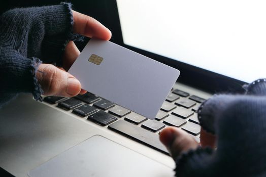 hacker hand stealing data from credit card .