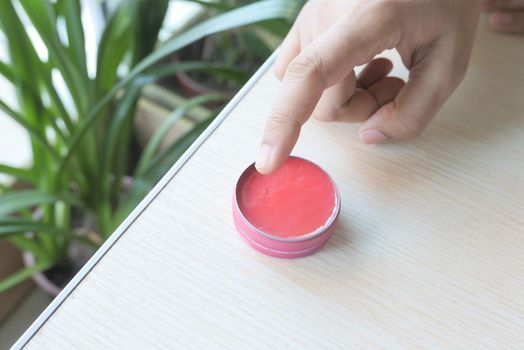 woman using petroleum jelly onto skin at home close up..
