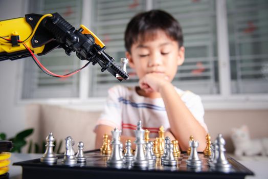 Asian little boy thinking and wait robot arm playing chess, STEM education E-learning, Funny children learning successful getting a lesson control robot arm game, Technology science education concept