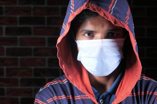 Close up of man with protective face mask looking at camera.