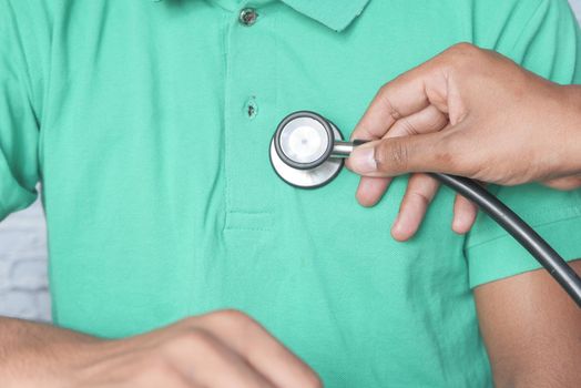 Doctor using a stethoscope checking body.