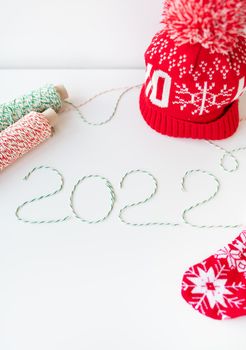 Holiday concept for Christmas and New Year 2022. Layout of various Christmas attributes - hat, sock, striped threads for packaging