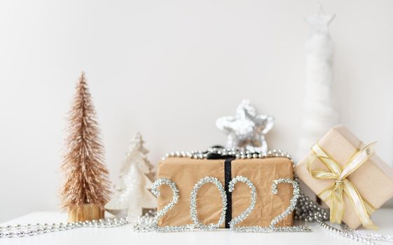 Banner Happy New Year 2022. Festive decor - Christmas tree, gift, star, tinsel. Blank copy space for decal or other objects