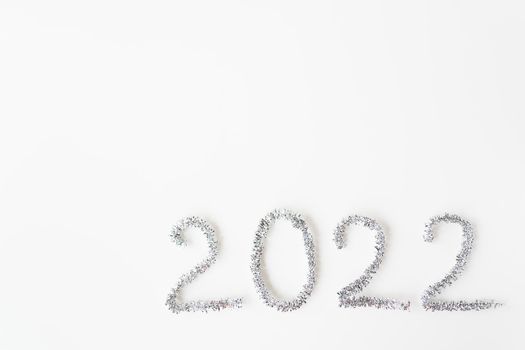 Happy new year 2022 written in foil and new year rain on an isolated white background. Happy new year greetings