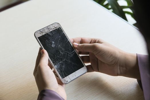 Close up of man hand holding broken smart phone