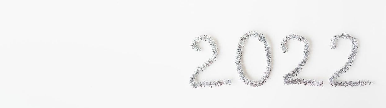 Baner happy new year 2022 written with foil and new year rain on an isolated white background. Happy new year greetings