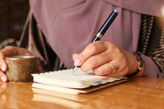 Close up of women hand writing on notepad