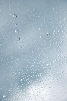 Close up of a window with raindrops. Vertical view