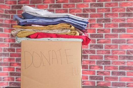 Donation box with donation clothes on a wooden background