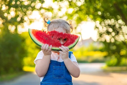 Child girl eats watermelon in summer. Selective focus. Food.