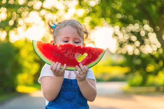 Child girl eats watermelon in summer. Selective focus. Food.