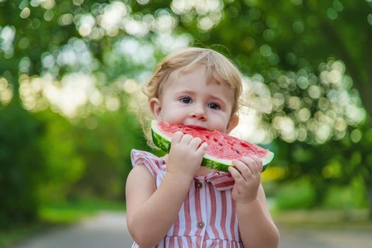 Child girl eats watermelon in summer. Selective focus. Food.