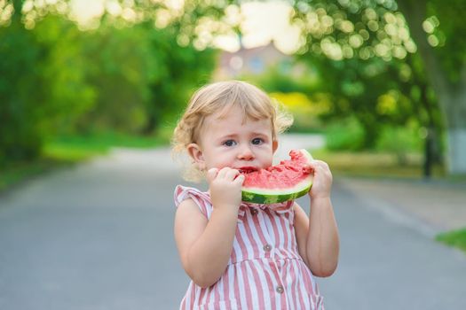 Child girl eats watermelon in summer. Selective focus. Food.