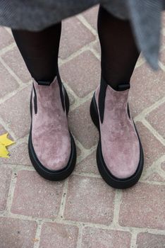 Women's autumn pink suede ankle boots. Fashion shoes. Outdoors. stone pavement