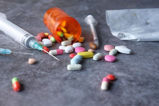 drug addiction concept with heroine packet and syringe on black backgrund .