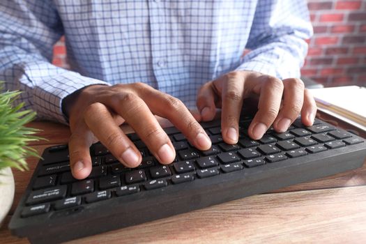 Close up of man hand typing on keyboard .