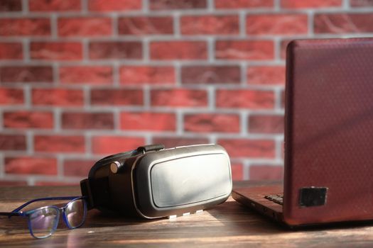 vr box , notepad and laptop on table .