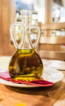 Natural food, Mediterranean diet and healthy eating concept - Bottles of organic extra virgin olive oil in Italian restaurant