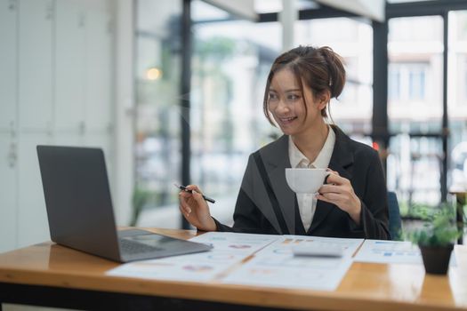 Portrait of asian business woman using laptop computer for financial analysis