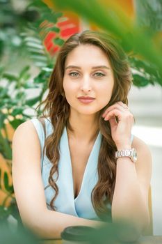 Portrait of a beautiful young caucasian woman sitting in flower garden outdoors