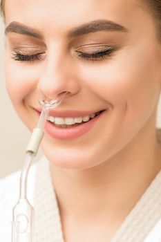 Beautiful happy young caucasian woman receiving nasal inhaler with essential oil smiling in a spa